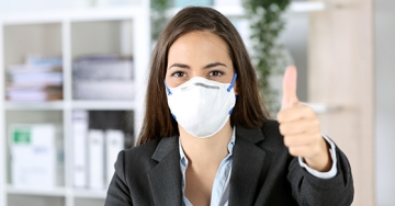 woman with mask thumbs up