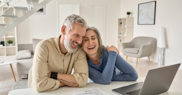 happy elderly couple on laptop computer