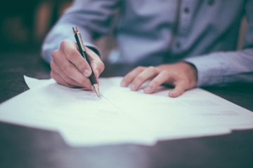 man signing paperwork in an office setting