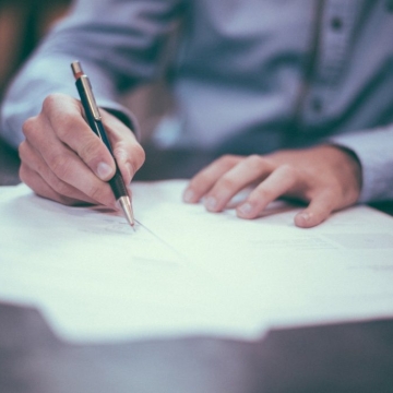 man signing paperwork in an office setting